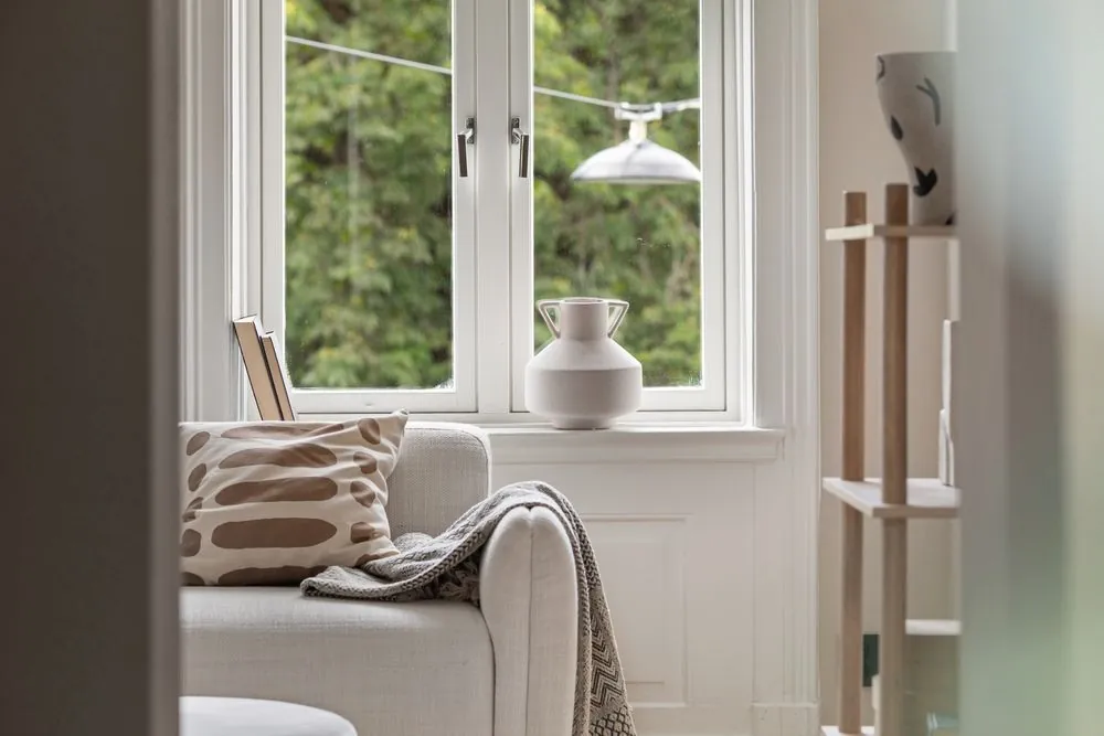 A window seat with cushions and a view of trees